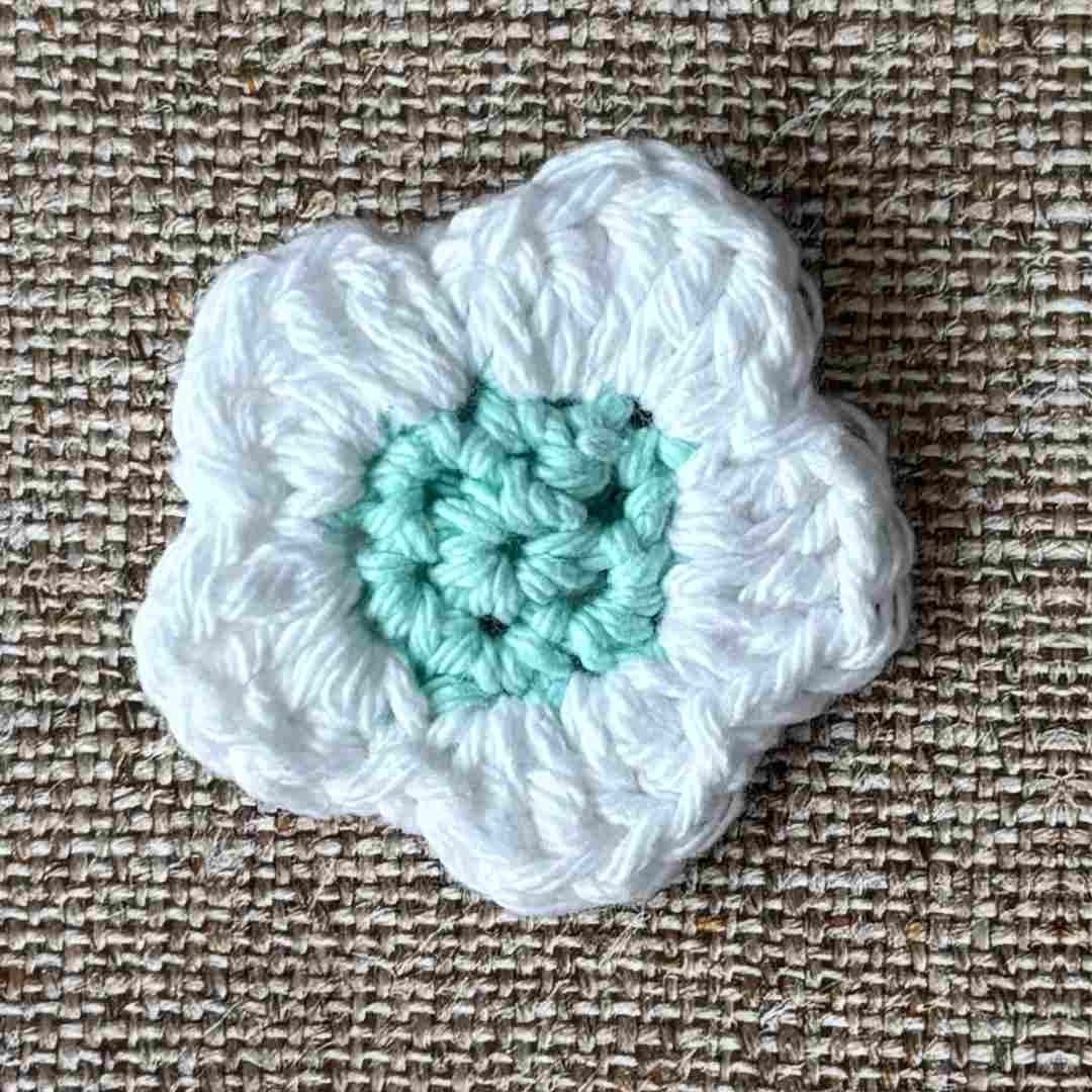 how to crochet a flower for beginners - step by step with pictures 11 crochet flower with blue center and white petals