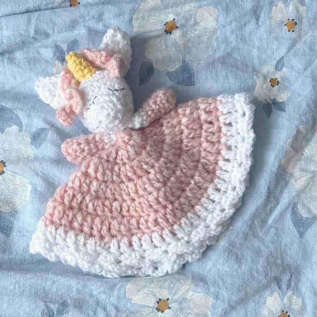 Unicorn Baby Lovey Crochet laying on a baby bed